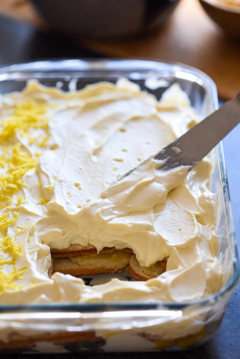 Individual lemon tiramisu dessert glass with creamy layers, lemon curd, whipped mascarpone, lemon slices, and mint